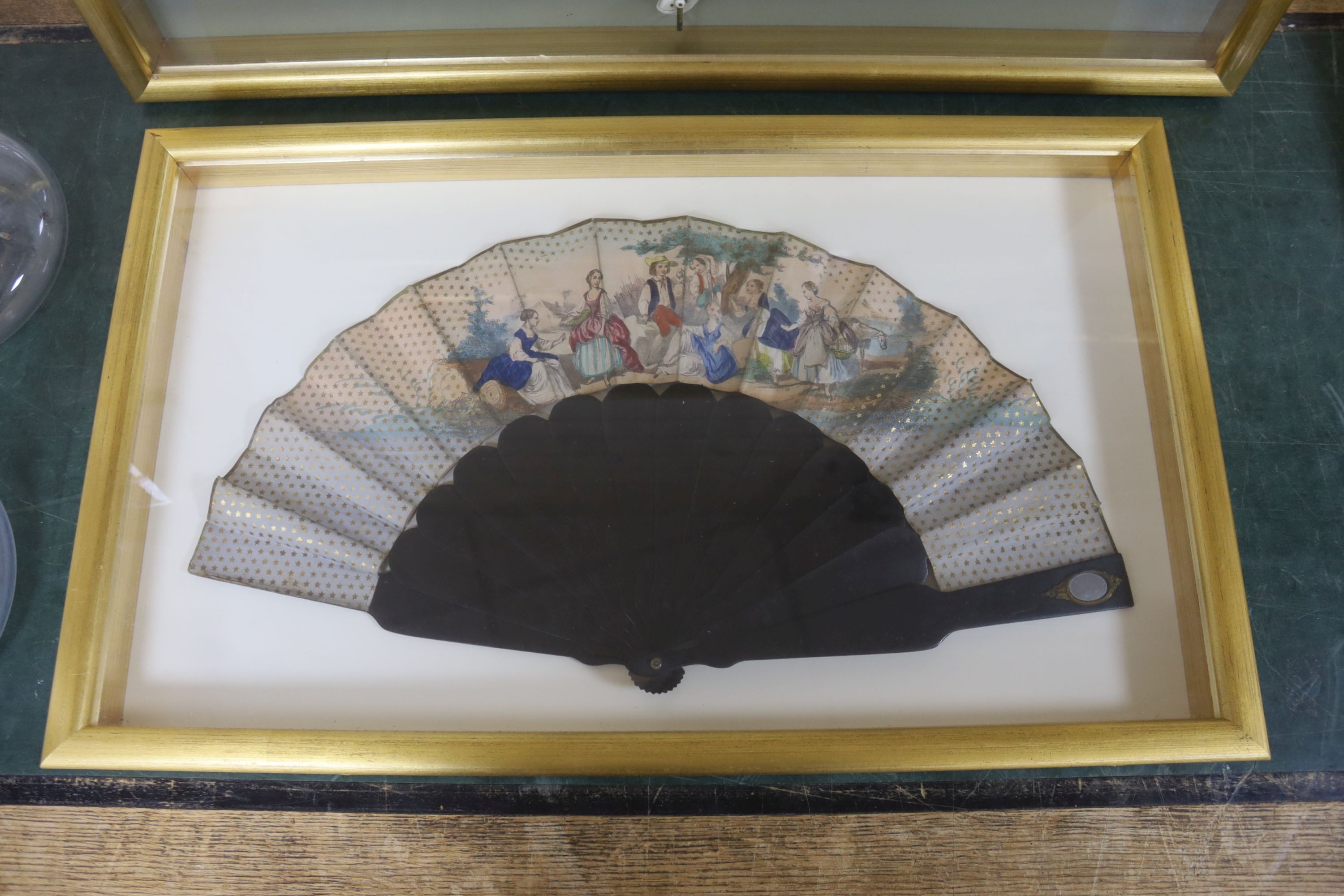 An early 19th century had tinted paper and ebony fan and two late 19th century ivory silk and bone fans, one painted with floral sprays, all three cased, largest case 46 x 71 cm (3)